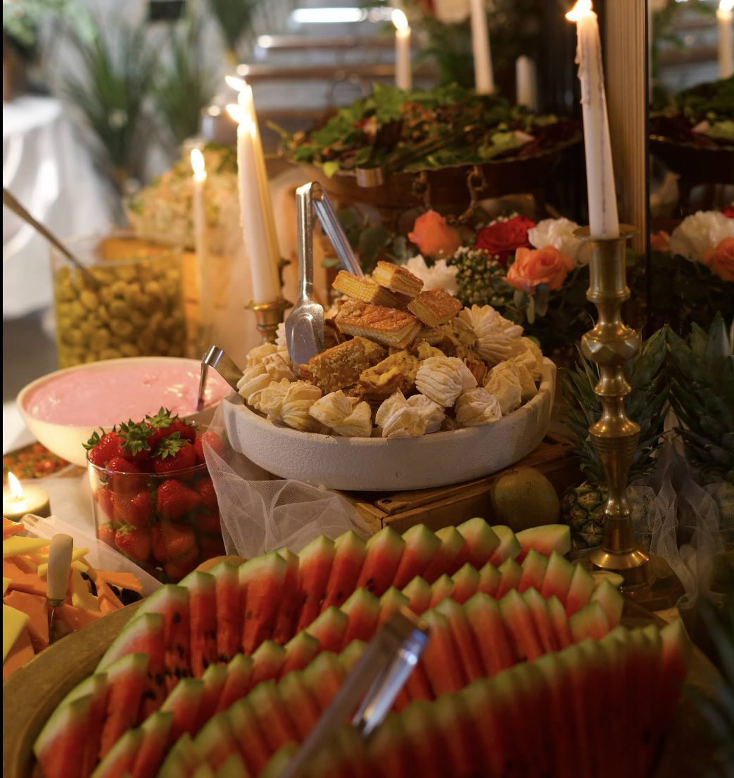 Candlelit table of Persian sweets, carved watermelon and fresh fruit